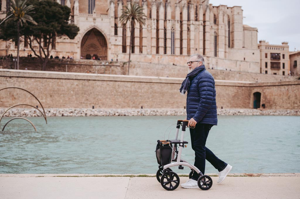 A man walks alongside a river with a Saljol walking frame
