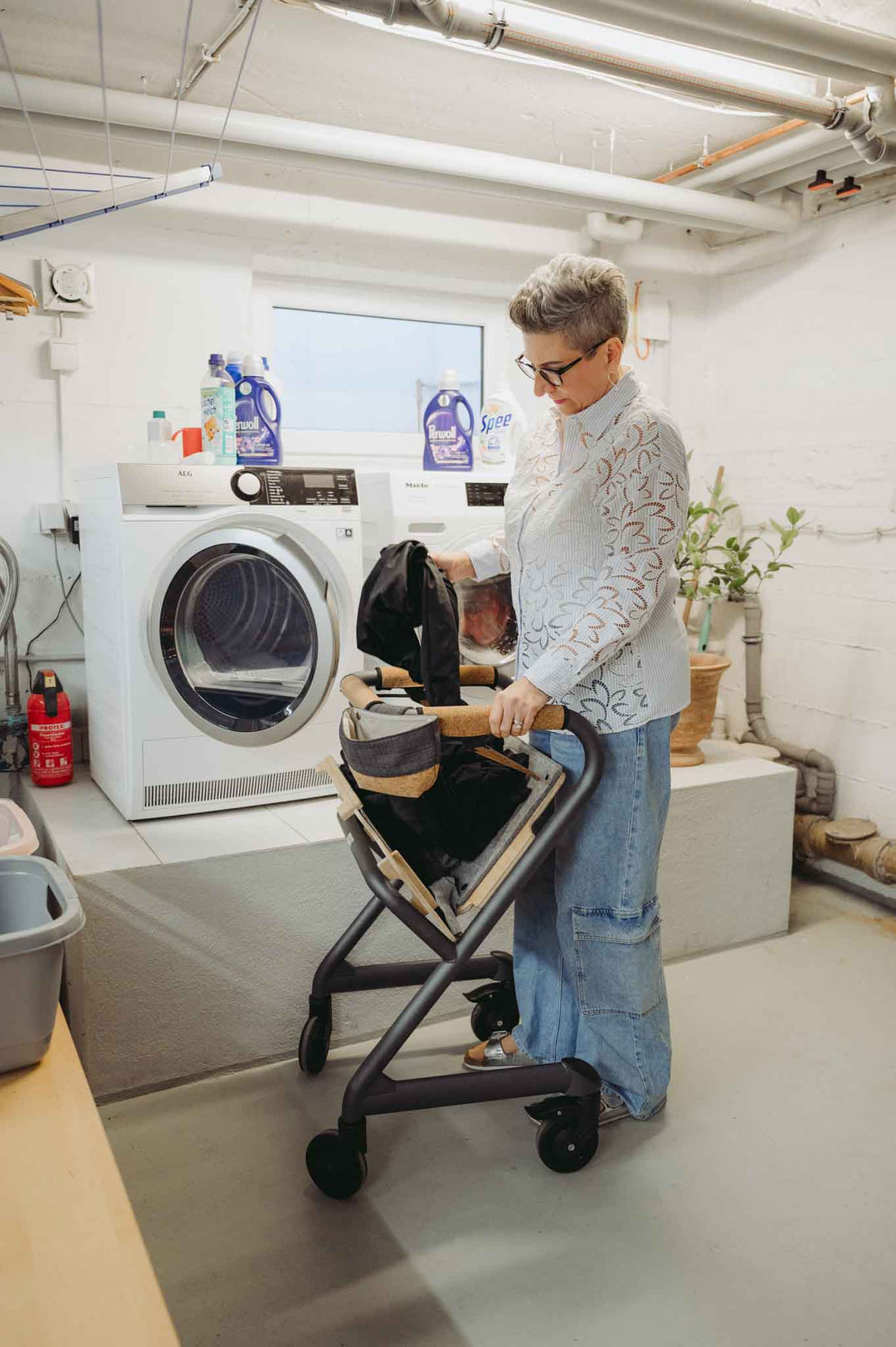 A women does the laundry while using a indoor mobility scooter for support