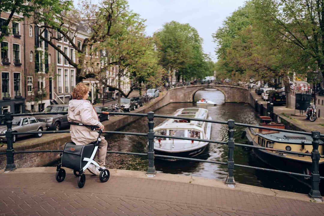 A woman sits on a Rollz Felx rollator looking over a canal in Amsterdam