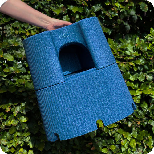 Blue interlocking step and stool held by a hand against a green leafy background