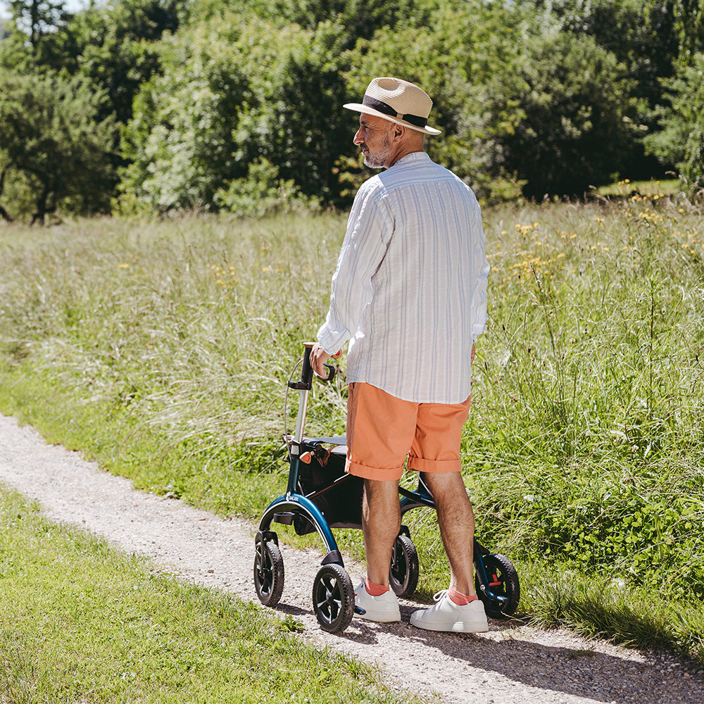 A man walks with a Saljol walking frame in a meadow