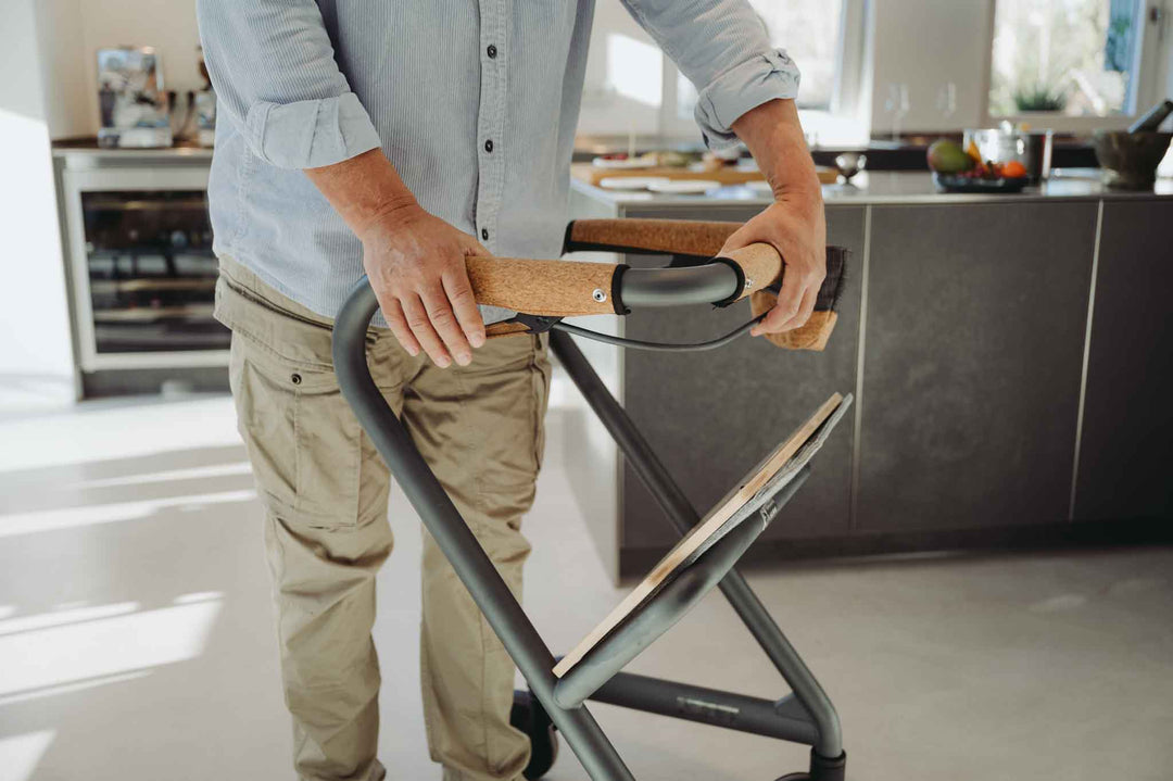 Person using the braking system on a indoor mobility walker in a kitchen setting