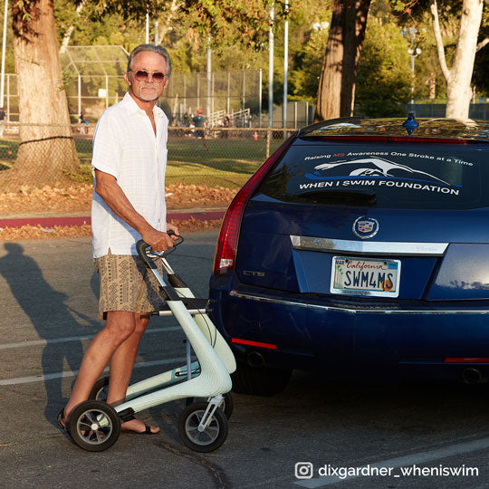 A man walks across a road with his walking frame rollator