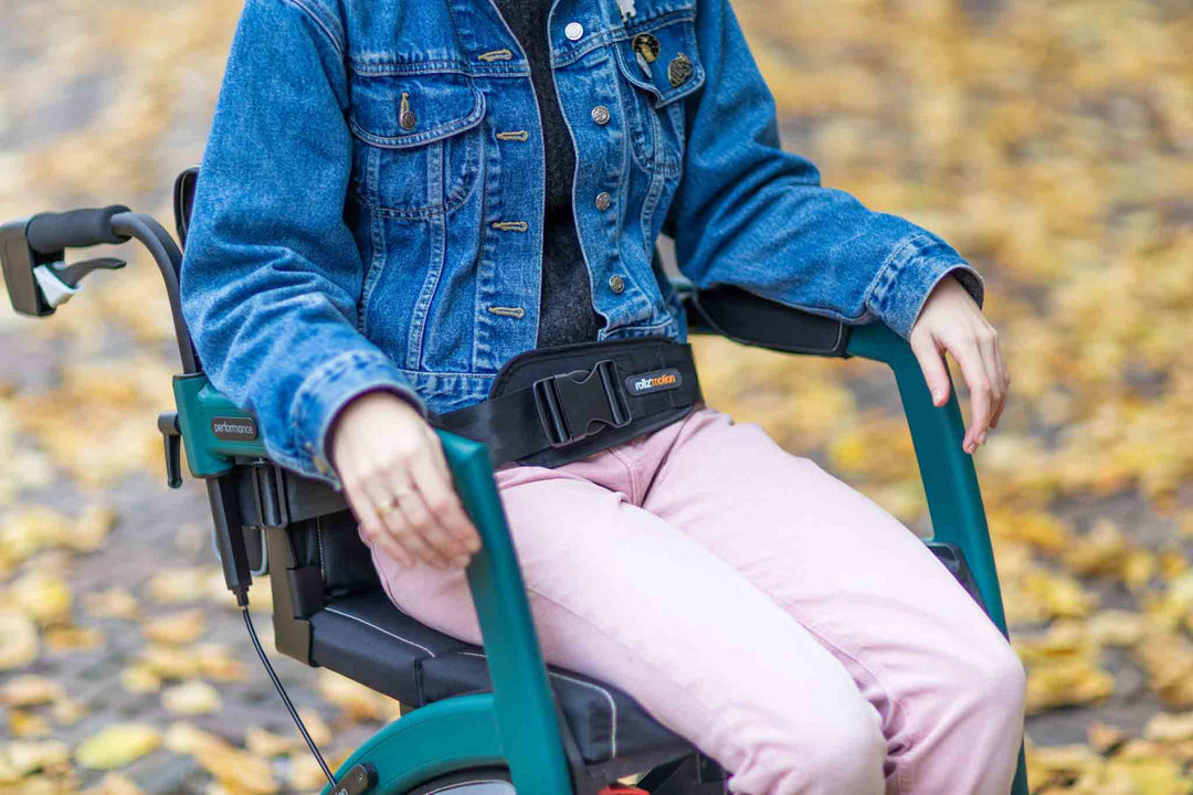 A close up of a person sitting in a 'Rollz Motion' walker wheelchair using the Rollz seatbelt 