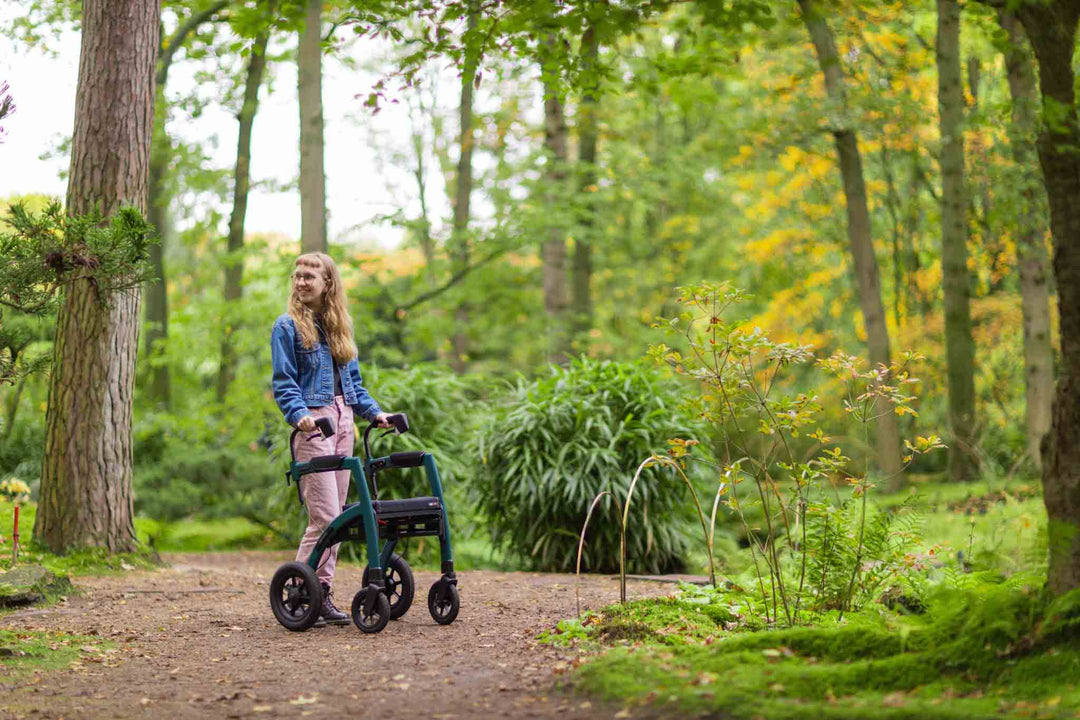 A girl uses a 'Rollz Motion Performance' rollator in a park surrounded by trees