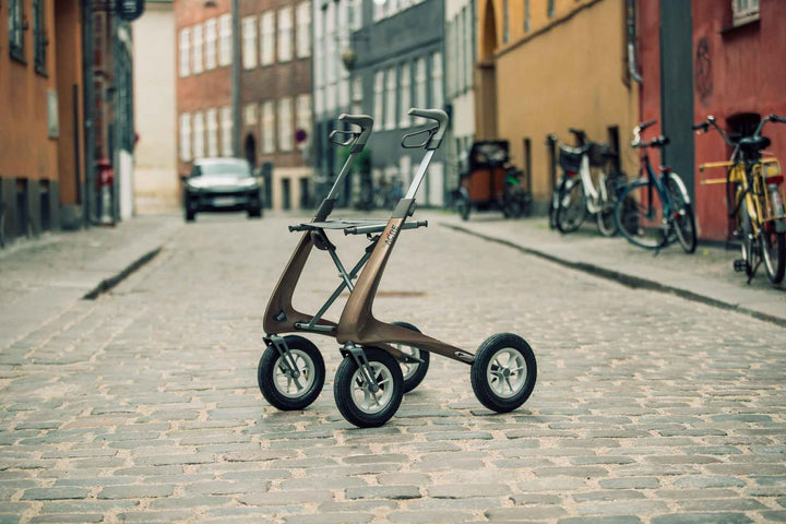A brown 'byACRE Carbon Overland' walker in the middle of a cobble stone street in Denmark